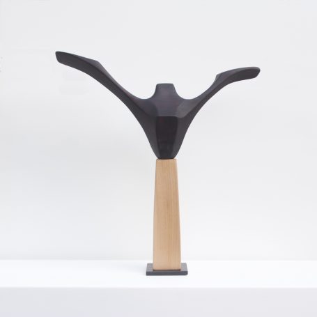 eine stilisierte Holzskulptur mit nach oben ausgebreiteten Armen - ein Symbol der Freude aus hellen und dunklen Holz.