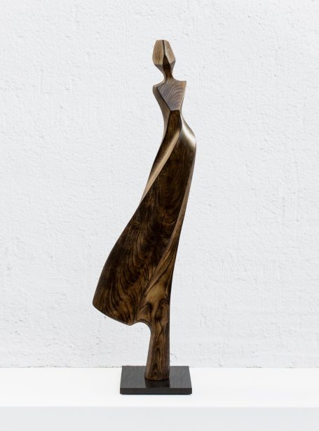 feminine, elegante Holzskulptur mit schwingenden Rock auf schwarzen Steinsockel von Bärbel Beran, Leipzig